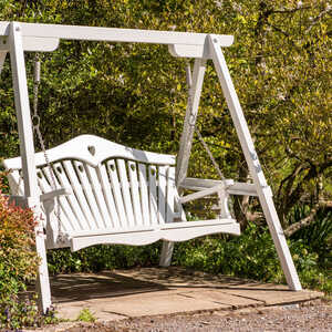 Painted swing seat set amongst shrubs