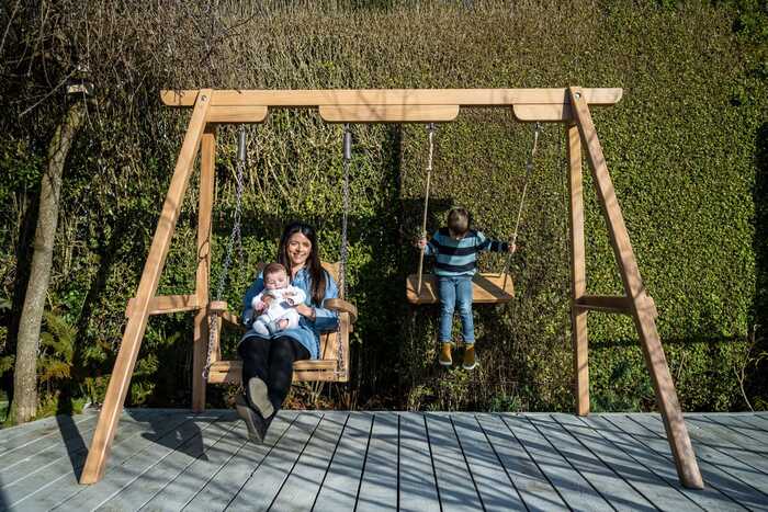 The Trilogy Garden Swing in Oak on a deck