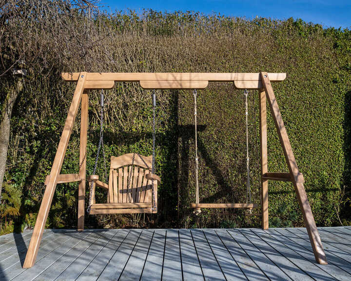 The Trilogy Garden Swing in Oak on a deck