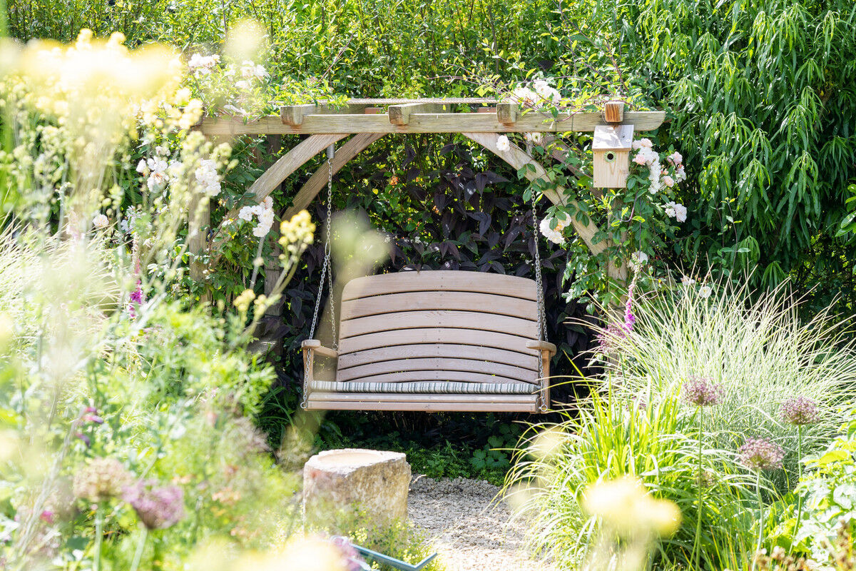 Swing Seat Hanging From Pergola in Garden