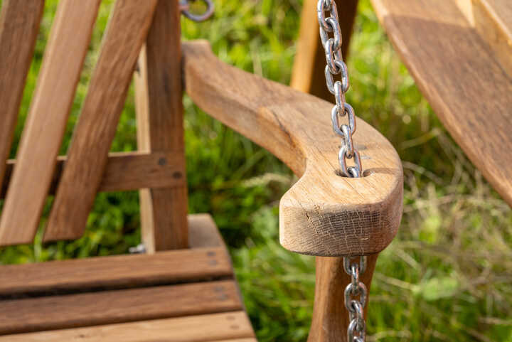 Painted swing seat set amongst shrubs