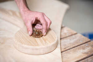 An ammonite being inset in to the arms of a swing bench
