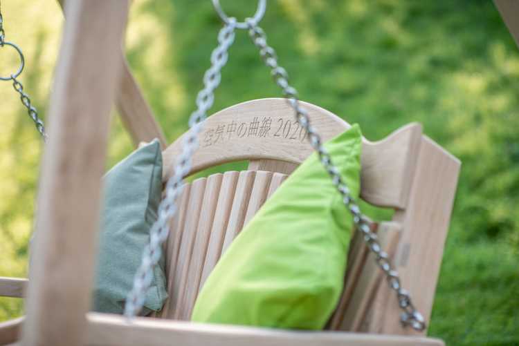 Wooden garden swing seat with a green cushion and bespoke engraving